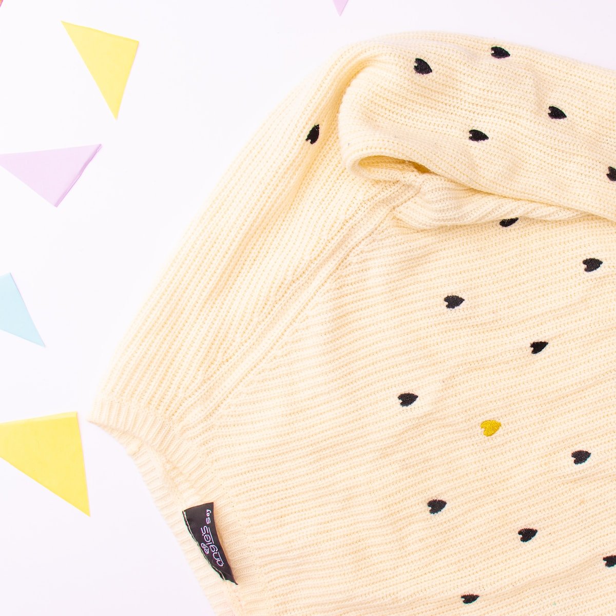 a yellow sweater with black dots on it